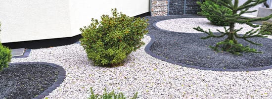 Moderner Steingarten mit geschwungenen Kiesflächen und minimalistischer Bepflanzung