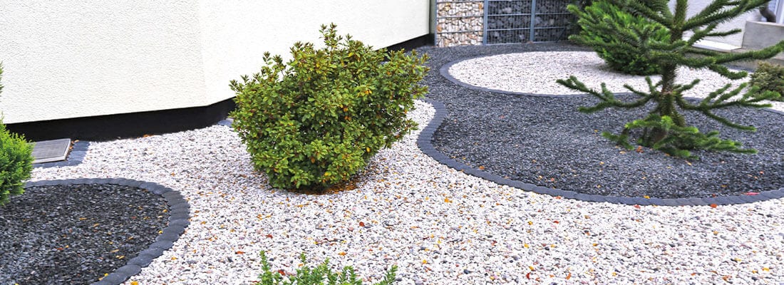 Moderner Steingarten mit geschwungenen Kiesflächen und minimalistischer Bepflanzung