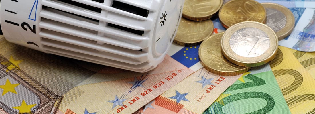 Feuer brennt auf einer Schicht von Holzpellets, die sich auf einem Boden ausbreiten. Der Hintergrund zeigt unscharfe Holzelemente.